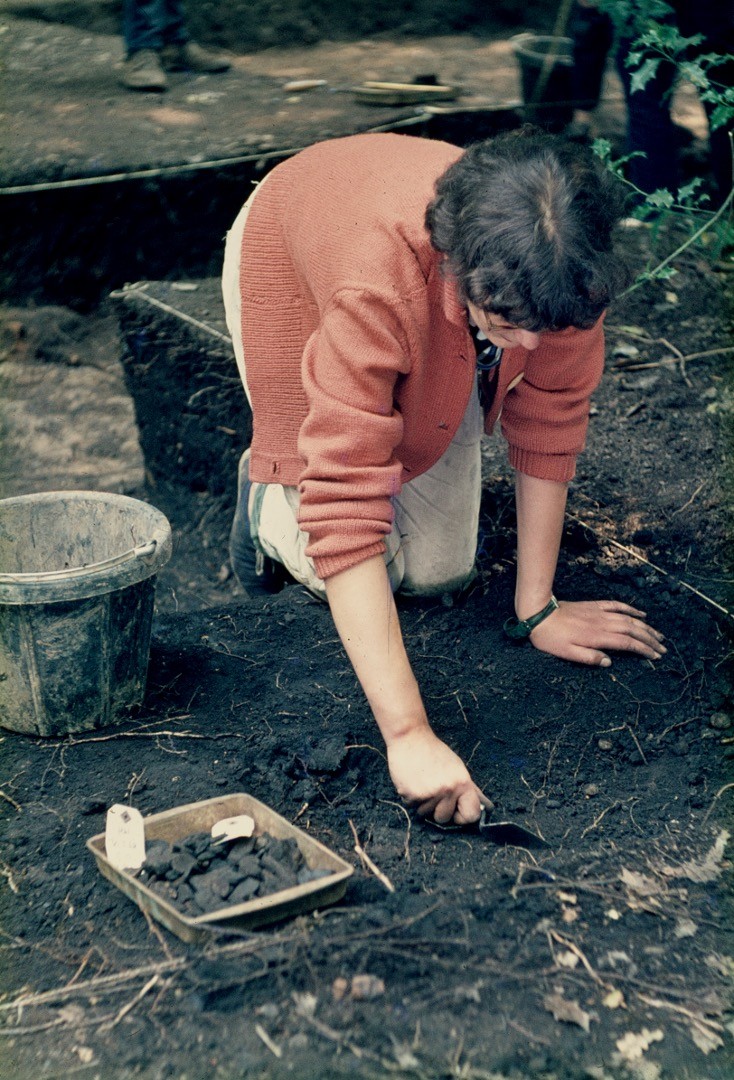Photo of female archaeologist digging.
